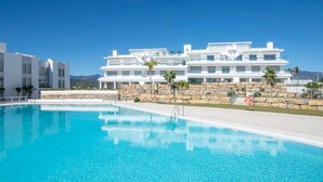 Ein modernes Hotel mit Schwimmbad, Steinwänden und blauem Himmel.