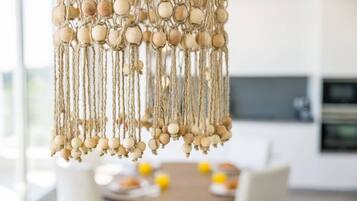 Un candelabro de macramé con cuentas de madera y cuerdas.