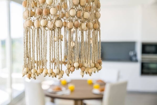 A macrame chandelier with wooden beads and ropes.