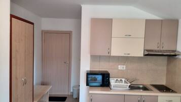 A compact kitchen with a microwave, sink, and cabinets.