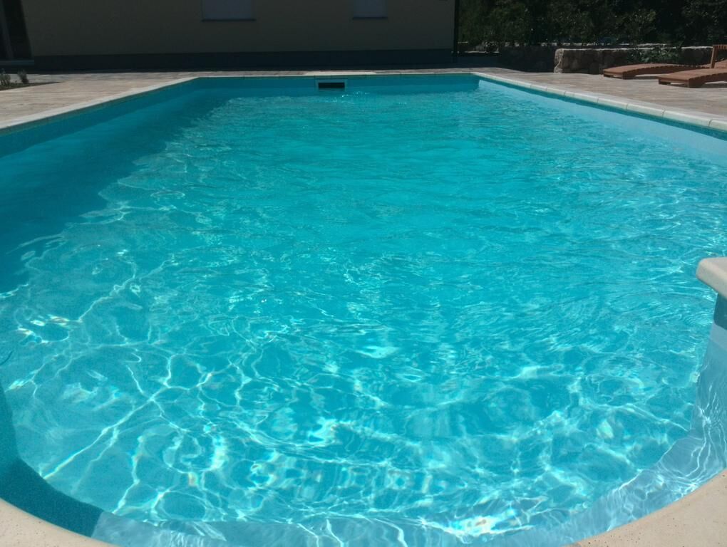 Et rektangulært swimmingpool med klart, blåt vand.