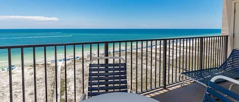 A balcony with a view of a beach and ocean.