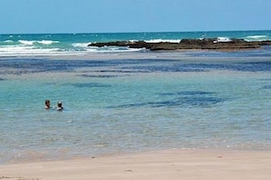 Na praia, espreguiçadeiras, toalhas de praia