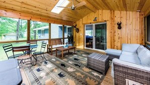 A wooden cabin interior with a dining area, a sofa, and a ceiling fan. - DD Ranch - Newly Renovated 10-Person Home! (Union Pier)