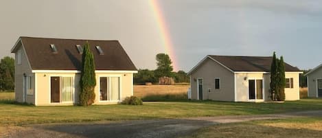 Une rangée de maisons à deux étages, avec une pelouse et un chemin de terre.