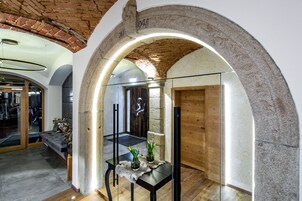 Un interior con un arco de piedra, una puerta de madera y un separador de vidrio.