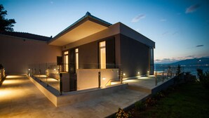 Ein modernes Haus mit Balkon, Pool und Meerblick.