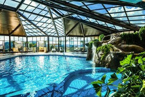 Una piscina techada, sillones reclinables de piscina