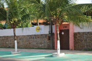 A building with a stone wall and a sign that reads "Sunshine".