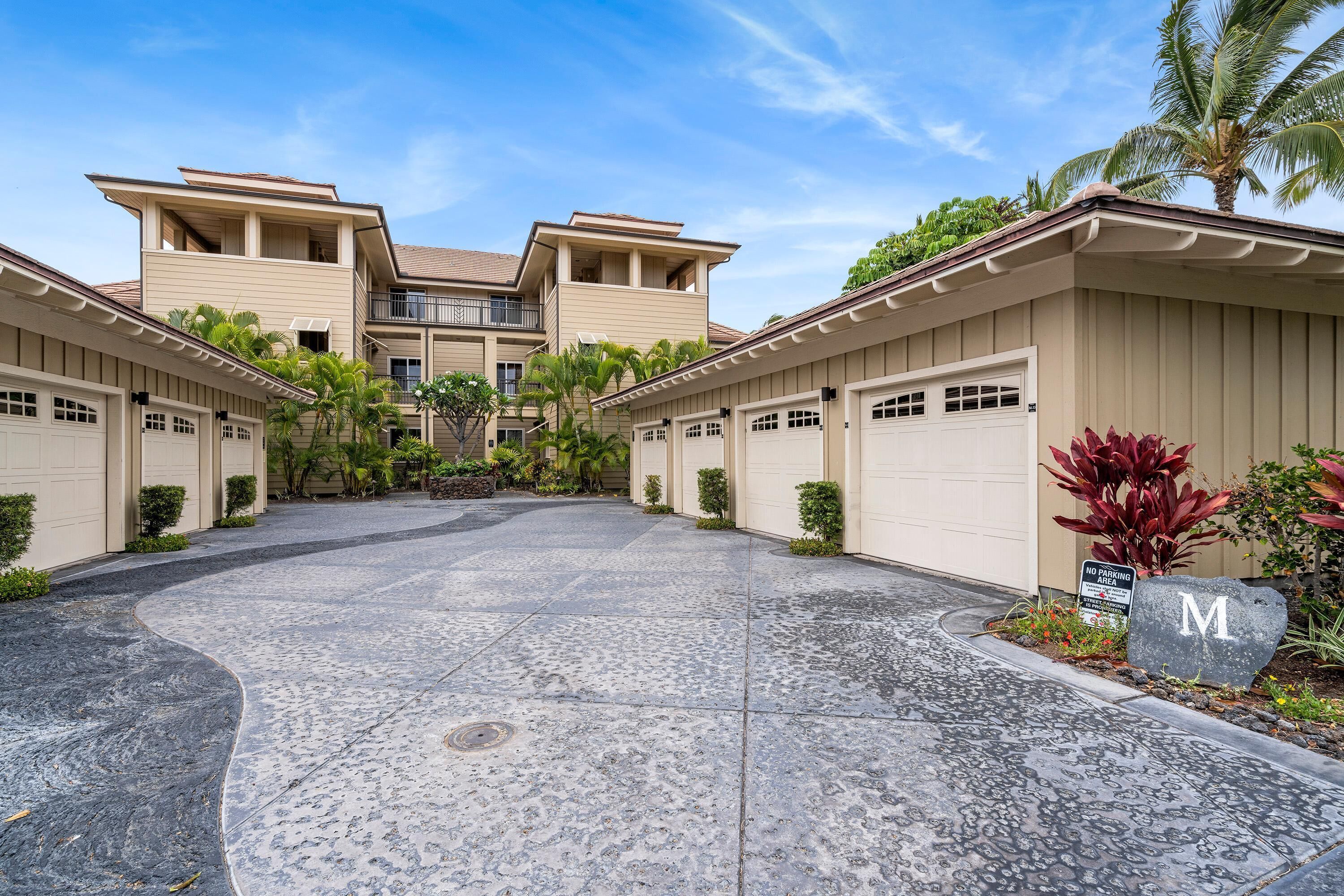 A residential area with two-story houses, a driveway, and a 'No Parking' sign.