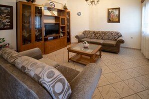 Relax in this inviting living room with a large cabinet, flat-screen TV, and comfortable sofa.