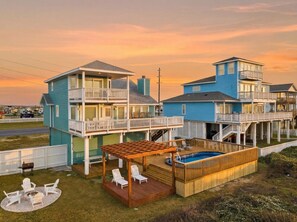 Een huis met twee verdiepingen, een balkon, een houten terras en een zwembad.