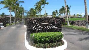 A stone sign with "The Capella" written on it, surrounded by greenery and palm trees. - Golf Villas at Mauna Lani - Unit K5 (Kamuela)