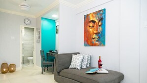 Una sala de estar moderna con un sofá gris, una pared de acento color turquesa y un cuadro abstracto de gran tamaño.