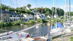 A marina with boats docked, a river, and houses in the background. - 3 bedroom stunning home in Langoat (Langoat)
