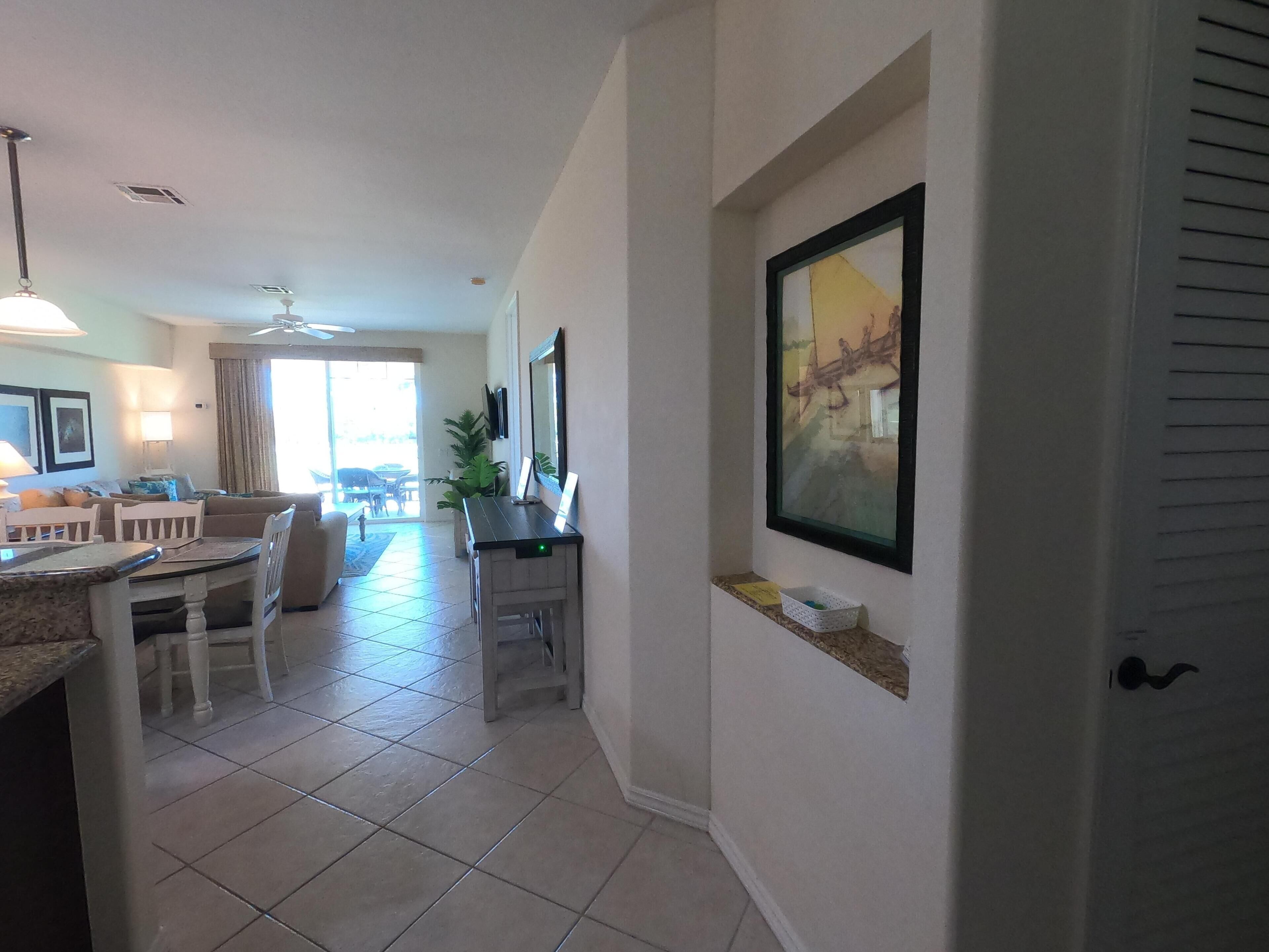 A spacious living area with a dining table, chairs, a sofa, and a kitchen area with a countertop and sink.