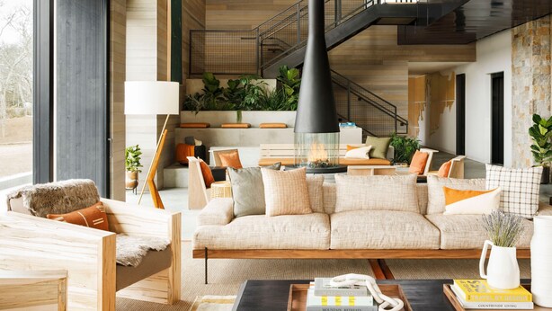 A modern living room with a sofa, coffee table, and various decorative items. - AutoCamp Cape Cod (Falmouth)