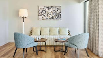 A modern room with a sofa, two armchairs, a coffee table, and a floor lamp.