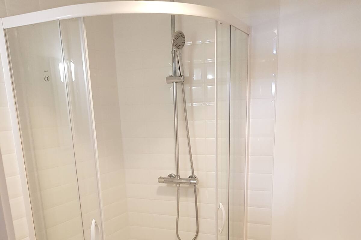 Un baño moderno con ducha de vidrio, inodoro y lavamanos.