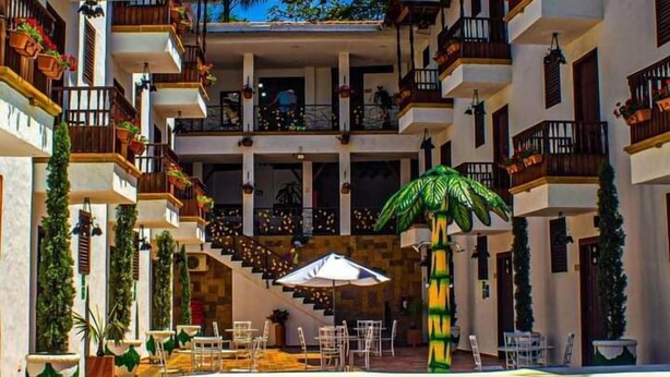 A hotel with a central courtyard, outdoor seating, and a swimming pool.