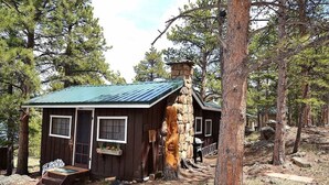 A rustic cabin with a stone chimney, wooden exterior, and a porch with steps leading to the entrance. - Little Mosser-Awesome Views! Very Quiet! (Estes Park)