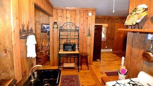 A wooden interior with a kitchen area, including a sink, microwave, and wooden shelves. - Little Mosser-Awesome Views! Very Quiet! (Estes Park)