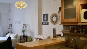 A compact kitchen with a central island, a sink, and wooden cabinets. - Cozy studio in the heart of Recoleta (CABA)