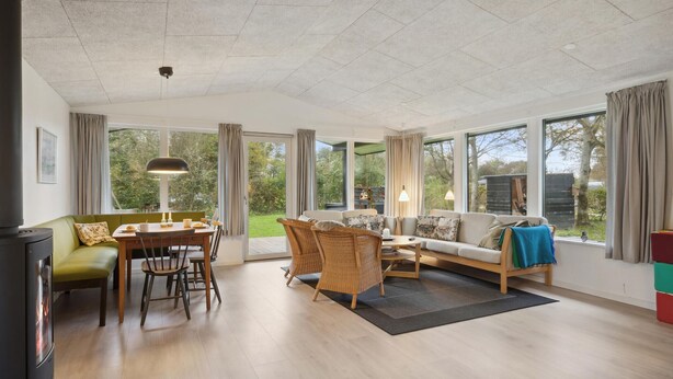 A spacious living area with a dining table, sofas, and a fireplace. - Amazing home in Hjerm with house a panoramic view (Hjerm)