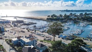 Un puerto deportivo con barcos amarrados, una playa y un área de estacionamiento.