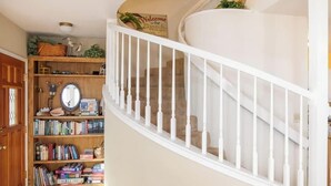Una escalera de caracol con balaustres blancos que lleva a un rellano.