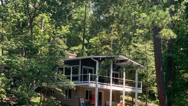 Uma casa à beira do lago com um cais e dois barcos.