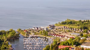A marina with boats docked, surrounded by residential buildings and greenery. - Cozy apartment in Rechlin with lake view (Rechlin)