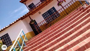 A building with a staircase leading to a balcony with a railing.