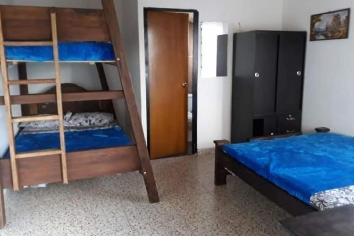 A room with a bunk bed, a wardrobe, and a door.