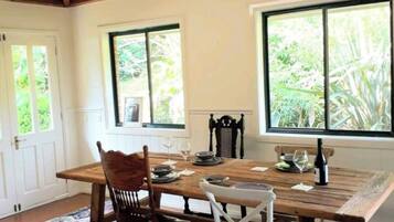 Un comedor con mesa de madera, sillas y alfombra estampada.