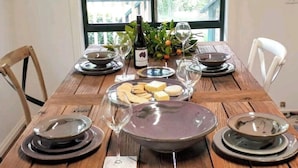 A rustic table with hand-made pottery, a bottle, and a window view. - Sandys Pottery Cottage- pet friendly, wineries, (Healesville)