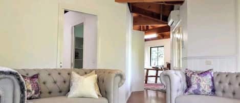Een ruime cottage met een bijzonder plafond in de hele ruimte, ingericht met zorgvuldig uitgekozen meubels.