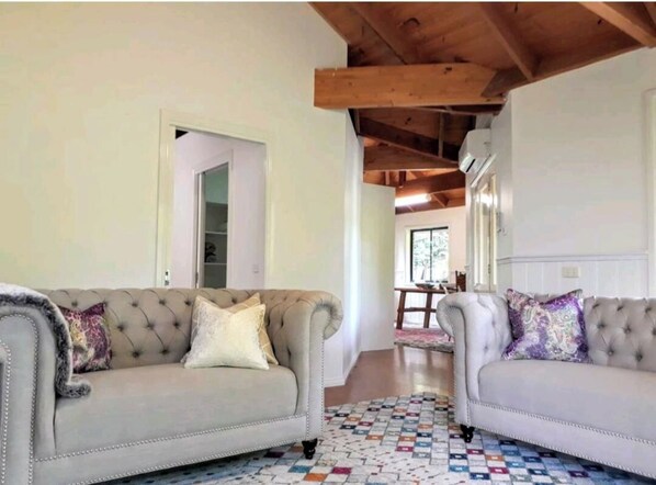 Una cabaña espaciosa con un techo de diseño distintivo en todo el espacio, que cuenta con muebles cuidadosamente escogidos.