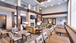 A spacious hotel lobby with multiple seating areas, including sofas and tables, and a high ceiling with exposed beams. - Free Breakfast. Pool & Hot Tub. Gym. Your Next Vacation! (Lehi)