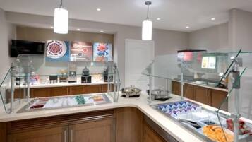 A buffet area with glass display cases, a television, and a variety of food items.