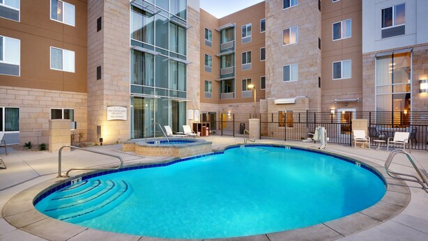 A hotel with a swimming pool, outdoor seating, and a sign indicating no lifeguard on duty. - Free Breakfast. Pool & Hot Tub. Gym. Near Traverse Mountain Shopping Center! (Lehi)