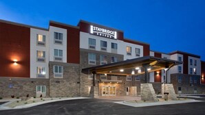 A Staybridge Suites hotel with a modern design, featuring a covered entrance and multiple floors.