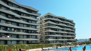 A multi-story hotel with balconies, a swimming pool, and a clear sky. - ROCAMAURA II 1-5 (Estartit)