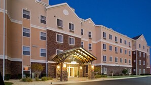 Un hotel de varios pisos con entrada cubierta, fachada de ladrillo y numerosas ventanas.
