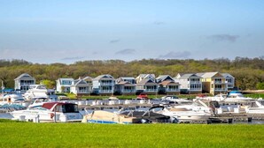 A marina with multiple boats docked and a row of houses in the background. - Harbor Master Villa #230 (Ottawa)