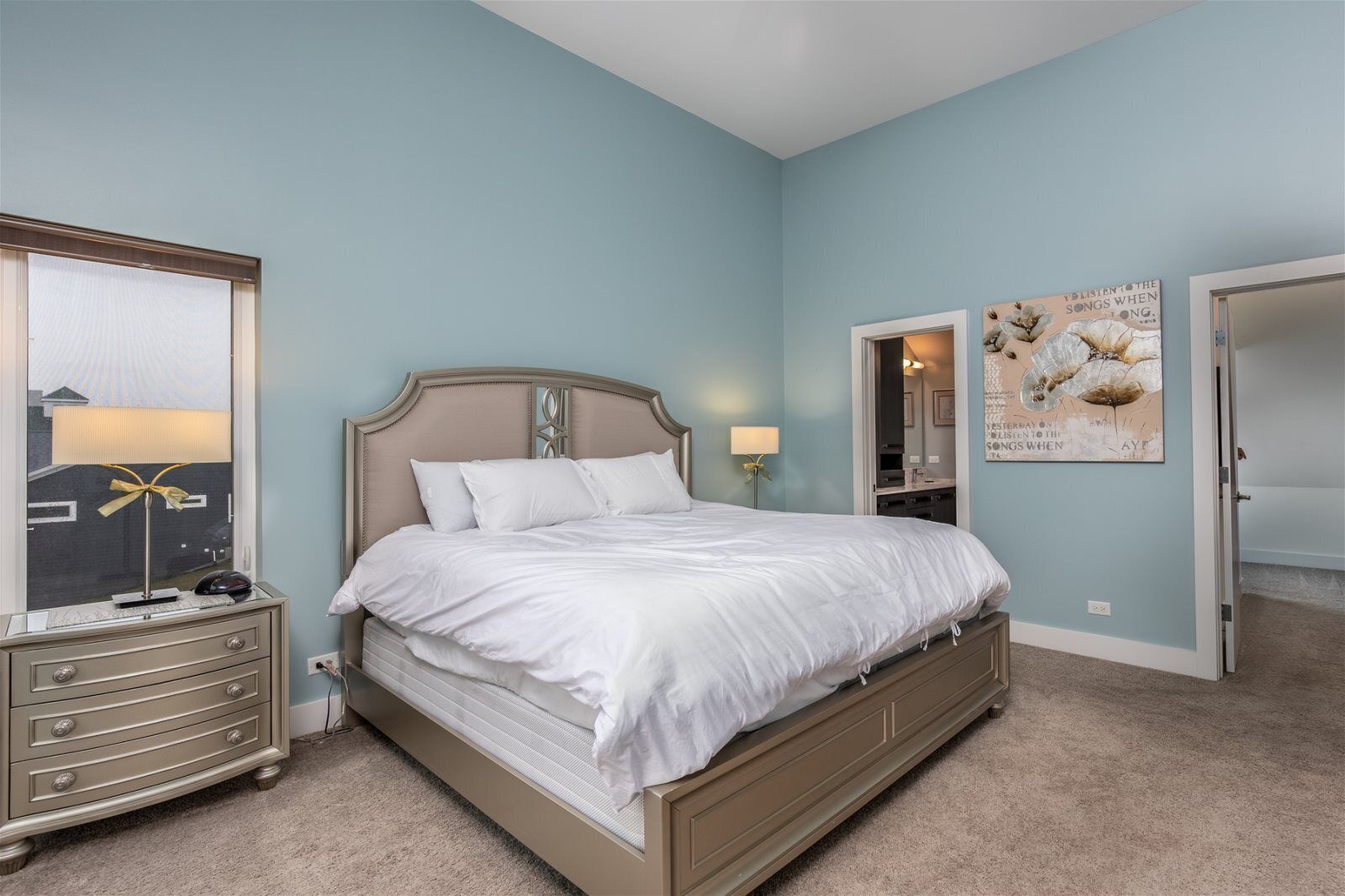 A bedroom with a bed, dresser, and a mirror.