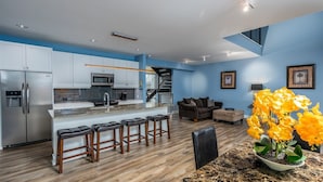A modern kitchen with a central island, bar stools, and a dining table with chairs. - Serenity 41W (Ottawa)