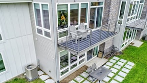 A modern two-story house with a balcony, large windows, and a stone facade. - Serenity 41W (Ottawa)