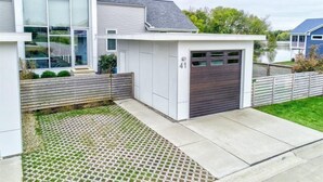 A modern two-story house with a garage, a covered driveway, and a small garden area. - Serenity 41W (Ottawa)