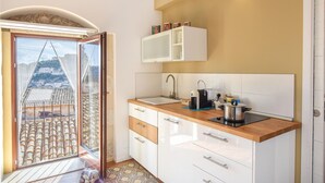 A kitchen with a view of a cityscape through a sliding door. - La casa dei Giarrentini (Modica)